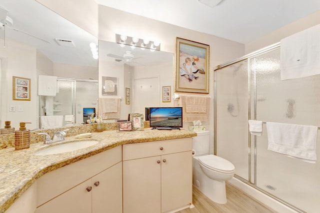 4101 Coral Tree Cir Unit 116, Coconut Creek, FL 33073 - full bathroom featuring ceiling fan, toilet, a stall shower, wood finished floors, and vanity