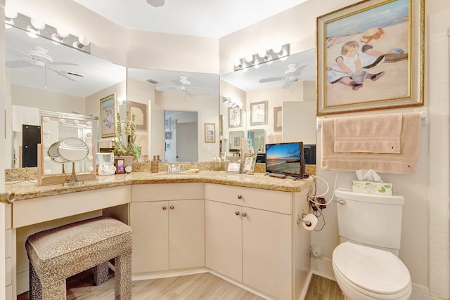 4101 Coral Tree Cir Unit 116, Coconut Creek, FL 33073 - bathroom with a ceiling fan, vanity, toilet, a shower with shower door, and wood finished floors