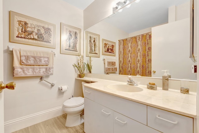 4101 Coral Tree Cir Unit 116, Coconut Creek, FL 33073 - full bathroom featuring vanity, toilet, wood finished floors, and baseboards