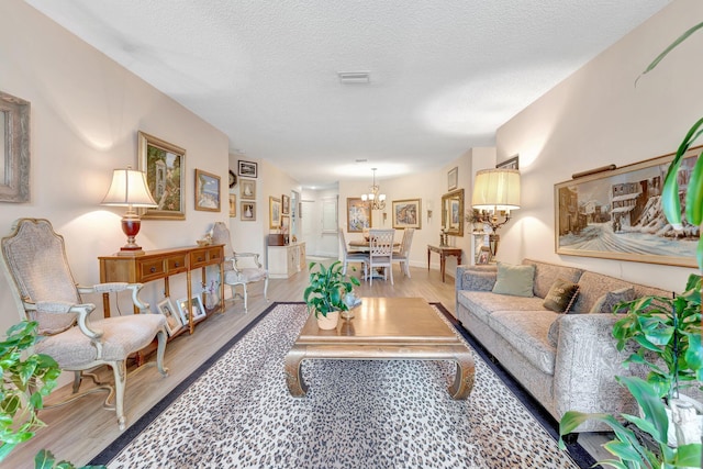 4101 Coral Tree Cir Unit 116, Coconut Creek, FL 33073 - living area featuring a chandelier, wood finished floors, and a textured ceiling