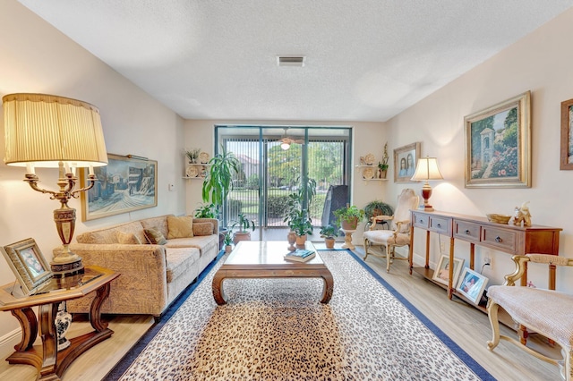 4101 Coral Tree Cir Unit 116, Coconut Creek, FL 33073 - living room with a textured ceiling and light wood-style flooring