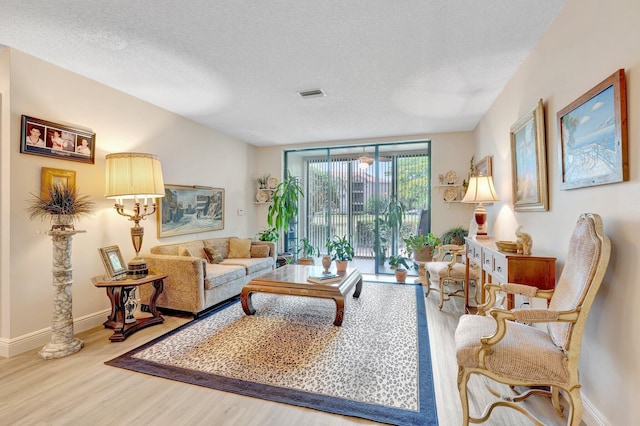 4101 Coral Tree Cir Unit 116, Coconut Creek, FL 33073 - living area with wood finished floors, baseboards, and a textured ceiling