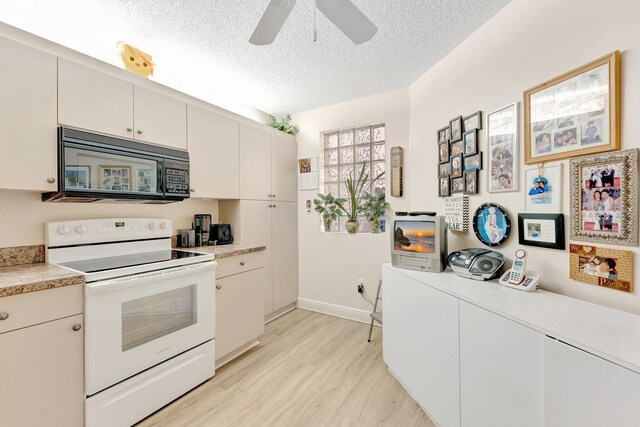 4101 Coral Tree Cir Unit 116, Coconut Creek, FL 33073 - kitchen featuring black microwave, electric stove, a textured ceiling, light wood-type flooring, and light countertops
