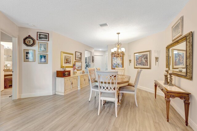 4101 Coral Tree Cir Unit 116, Coconut Creek, FL 33073 - dining area featuring light wood finished floors, baseboards, a chandelier, and a textured ceiling