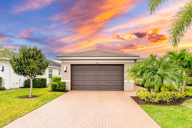 11688 SW Brighton Falls Dr, Port Saint Lucie, FL 34987 - view of front of house featuring decorative driveway, stucco siding, a front yard, a garage, and a tile roof