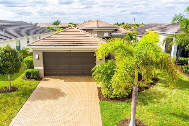 11688 SW Brighton Falls Dr, Port Saint Lucie, FL 34987 - view of front of house featuring a garage, stucco siding, decorative driveway, a front yard, and a tile roof