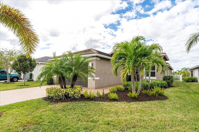 11688 SW Brighton Falls Dr, Port Saint Lucie, FL 34987 - view of property exterior featuring decorative driveway, stucco siding, a yard, and an attached garage