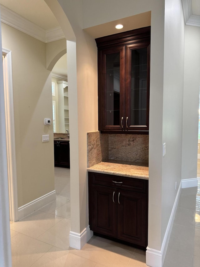 10469 Whitewind Cir, Boynton Beach, FL 33473 - bar featuring ornamental molding, arched walkways, tasteful backsplash, light tile patterned floors, and baseboards