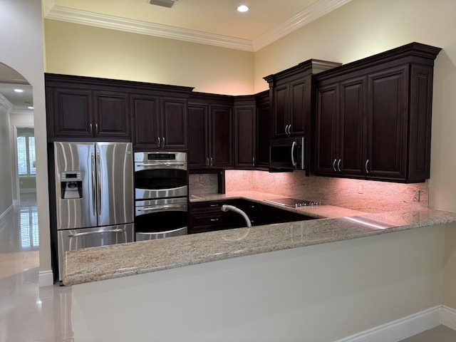 10469 Whitewind Cir, Boynton Beach, FL 33473 - kitchen with stainless steel appliances, arched walkways, backsplash, light stone counters, and ornamental molding