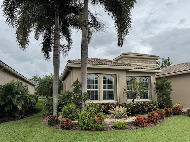10469 Whitewind Cir, Boynton Beach, FL 33473 - view of side of property with a tiled roof, a yard, and stucco siding