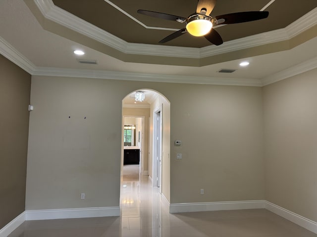 10469 Whitewind Cir, Boynton Beach, FL 33473 - tiled empty room with arched walkways, a ceiling fan, crown molding, a tray ceiling, and baseboards