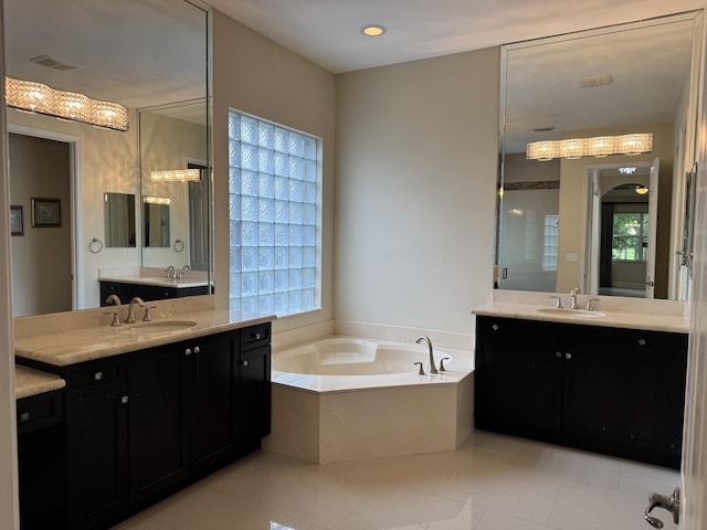 10469 Whitewind Cir, Boynton Beach, FL 33473 - full bath with two vanities, a garden tub, tile patterned flooring, and healthy amount of natural light