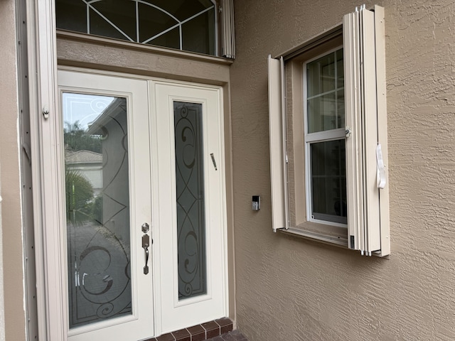 10469 Whitewind Cir, Boynton Beach, FL 33473 - view of exterior entry with stucco siding and french doors