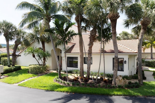 508 Sea Oats Dr Unit A-1, Juno Beach, FL 33408 - mediterranean / spanish-style house featuring stucco siding, a tile roof, and a front lawn