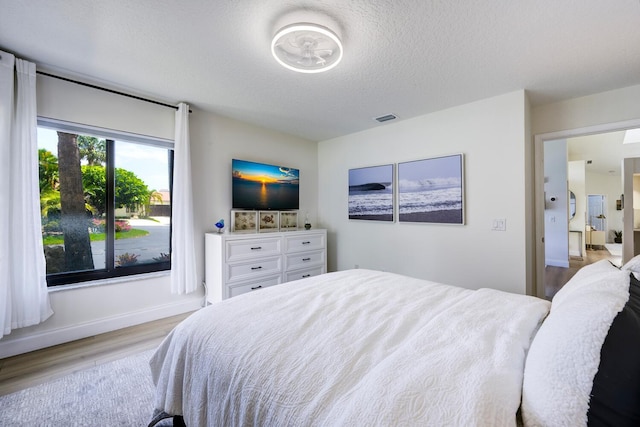 508 Sea Oats Dr Unit A-1, Juno Beach, FL 33408 - bedroom featuring wood finished floors, a textured ceiling, and baseboards