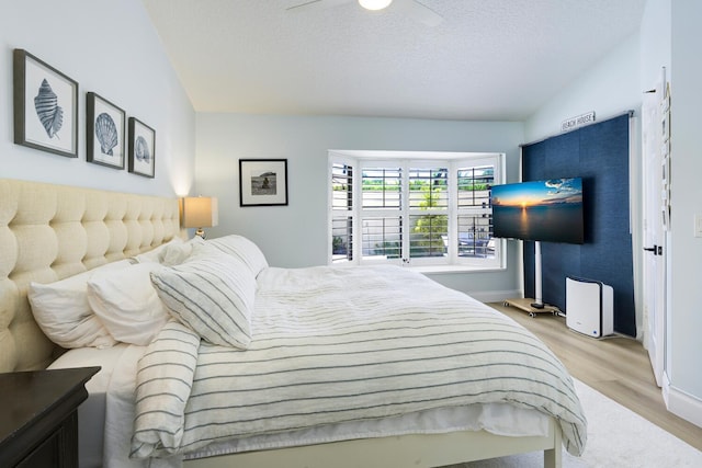 508 Sea Oats Dr Unit A-1, Juno Beach, FL 33408 - bedroom with light wood-style flooring, baseboards, a ceiling fan, and a textured ceiling