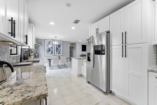 4501 N Australian Ave, West Palm Beach, FL 33407 - kitchen with stainless steel fridge with ice dispenser, recessed lighting, white cabinets, decorative backsplash, and light stone countertops