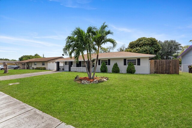 4501 N Australian Ave, West Palm Beach, FL 33407 - ranch-style house with concrete driveway and an attached garage