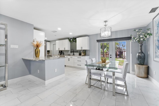 4501 N Australian Ave, West Palm Beach, FL 33407 - dining space featuring light marble finish flooring, baseboards, french doors, a chandelier, and recessed lighting