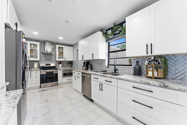 4501 N Australian Ave, West Palm Beach, FL 33407 - kitchen with appliances with stainless steel finishes, wall chimney exhaust hood, a sink, light marble finish flooring, and white cabinets