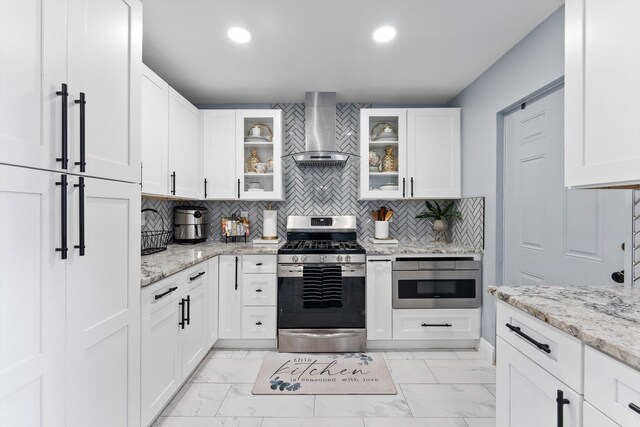 4501 N Australian Ave, West Palm Beach, FL 33407 - kitchen with stainless steel gas stove, wall chimney range hood, light marble finish floors, tasteful backsplash, and recessed lighting