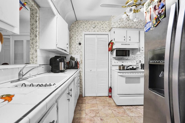 14775 Wildflower Ln, Delray Beach, FL 33446 - kitchen featuring stainless steel fridge, white range with electric stovetop, a sink, tile countertops, and white cabinets