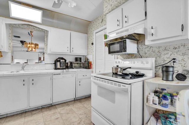 14775 Wildflower Ln, Delray Beach, FL 33446 - kitchen with white appliances, a sink, tile countertops, white cabinetry, and wallpapered walls