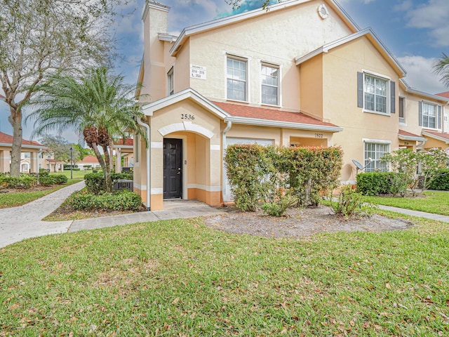 2536 57th Cir, Vero Beach, FL 32966 - view of property featuring stucco siding, a front lawn, and a chimney