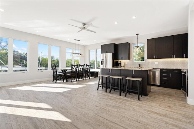 10851 S Ocean Dr Unit 84, Jensen Beach, FL 34957 - kitchen with appliances with stainless steel finishes, recessed lighting, a breakfast bar, a center island, and decorative light fixtures