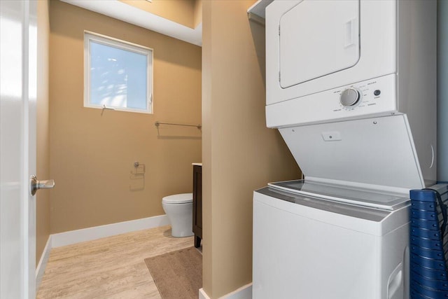 10851 S Ocean Dr Unit 84, Jensen Beach, FL 34957 - laundry area featuring estacked washer and dryer, wood finished floors, and baseboards