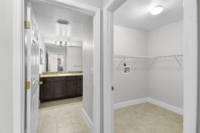 1595 SE Pomeroy St, Stuart, FL 34997 - laundry area featuring hookup for a washing machine, a textured ceiling, light tile patterned floors, and baseboards