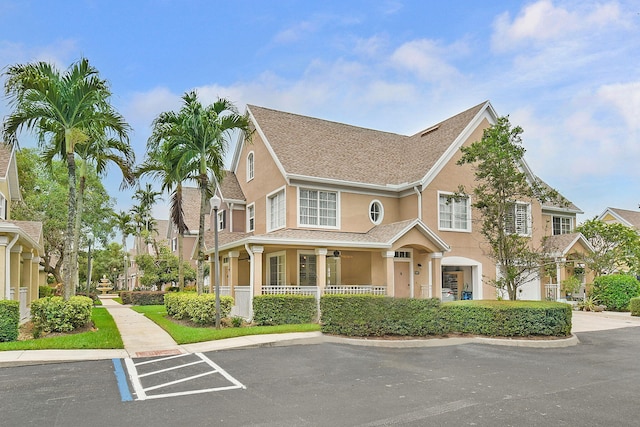1595 SE Pomeroy St, Stuart, FL 34997 - view of front of property with stucco siding, roof with shingles, covered porch, uncovered parking, and ceiling fan