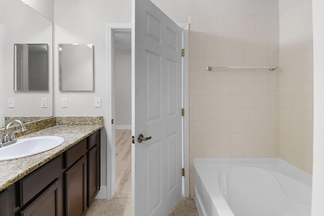 1595 SE Pomeroy St, Stuart, FL 34997 - bathroom with a tub to relax in, vanity, tile patterned floors, and baseboards