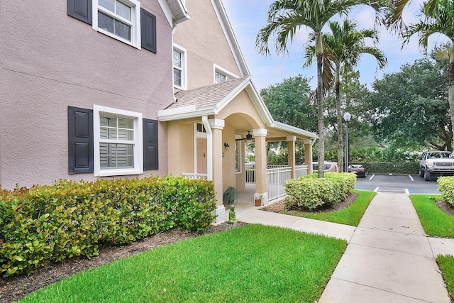 1595 SE Pomeroy St, Stuart, FL 34997 - view of exterior entry featuring stucco siding, covered porch, and a lawn
