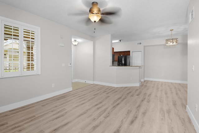 1595 SE Pomeroy St, Stuart, FL 34997 - unfurnished living room featuring light wood-style flooring, a ceiling fan, and baseboards