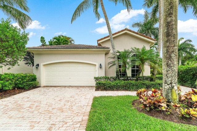 102 Andalusia Way, Palm Beach Gardens, FL 33418 - mediterranean / spanish home with a tile roof, an attached garage, decorative driveway, and stucco siding