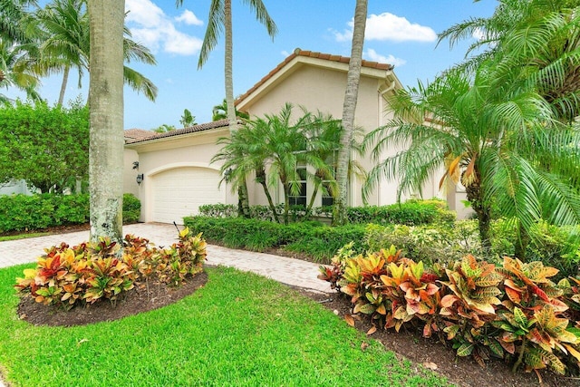 102 Andalusia Way, Palm Beach Gardens, FL 33418 - mediterranean / spanish-style house featuring decorative driveway, an attached garage, stucco siding, and a tile roof