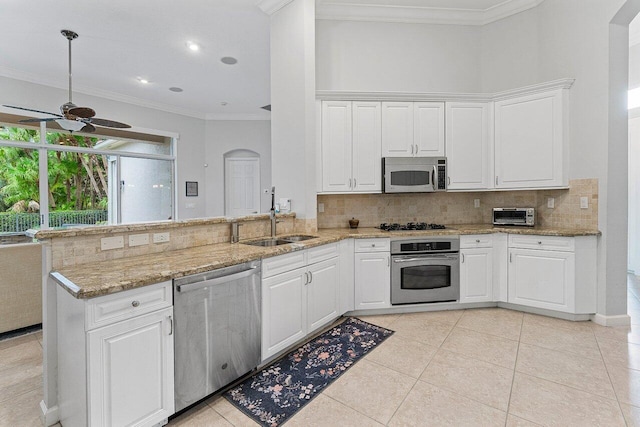 102 Andalusia Way, Palm Beach Gardens, FL 33418 - kitchen with stainless steel appliances, a sink, a ceiling fan, backsplash, and a peninsula
