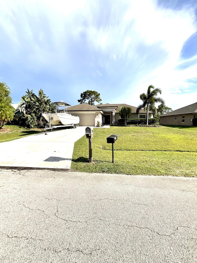1206 SW Bargello Ave SW, Port Saint Lucie, FL 34953 - view of front facade featuring concrete driveway, a front lawn, and an attached garage