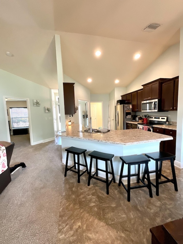 1206 SW Bargello Ave SW, Port Saint Lucie, FL 34953 - kitchen featuring stainless steel appliances, vaulted ceiling, a breakfast bar, dark brown cabinets, and a sink
