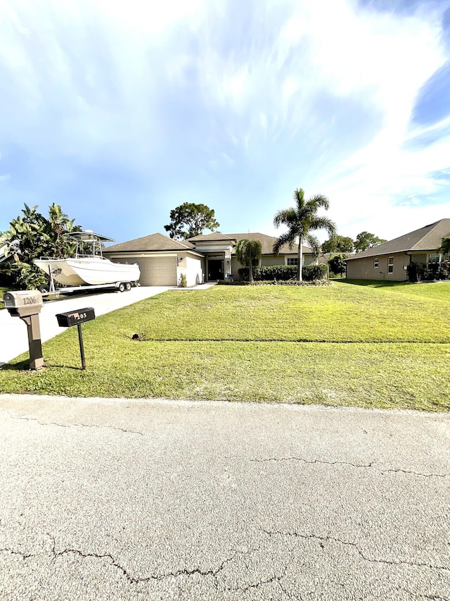 1206 SW Bargello Ave SW, Port Saint Lucie, FL 34953 - view of front of property with a garage, concrete driveway, a front yard, and stucco siding
