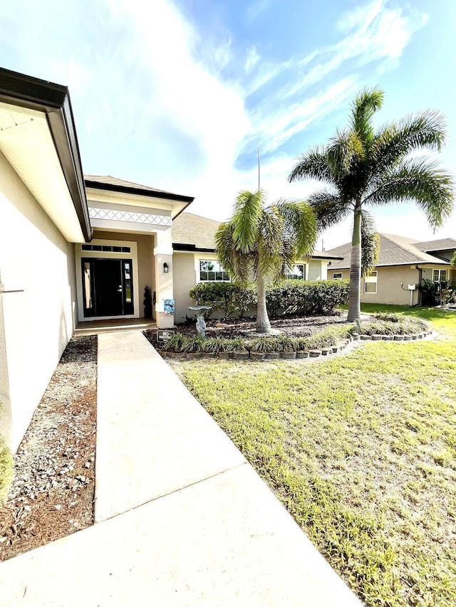 1206 SW Bargello Ave SW, Port Saint Lucie, FL 34953 - doorway to property with stucco siding and a yard