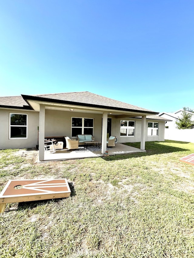 1206 SW Bargello Ave SW, Port Saint Lucie, FL 34953 - back of house featuring stucco siding, a lawn, an outdoor living space, a patio area, and a shingled roof