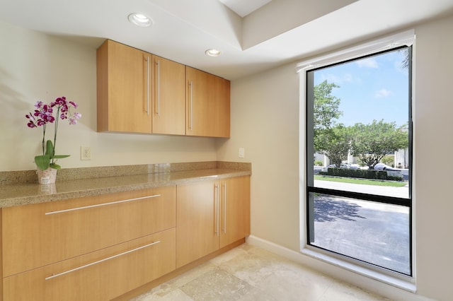 1700 Presidential Way Unit 201, West Palm Beach, FL 33401 - kitchen with light countertops, light brown cabinets, recessed lighting, baseboards, and light tile patterned floors