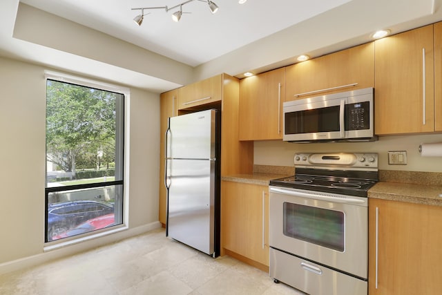 1700 Presidential Way Unit 201, West Palm Beach, FL 33401 - kitchen featuring stainless steel appliances, baseboards, light countertops, light brown cabinets, and light tile patterned floors
