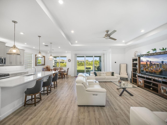 9817 SW Isabelline Dr, Port Saint Lucie, FL 34987 - living room with ceiling fan, light wood finished floors, recessed lighting, and a tray ceiling