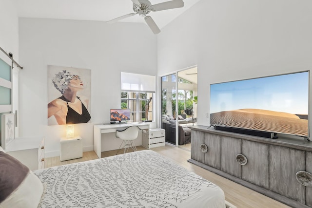 13853 Palm Grove Pl, West Palm Beach, FL 33418 - bedroom with a high ceiling, wood finished floors, a desk, a ceiling fan, and a barn door