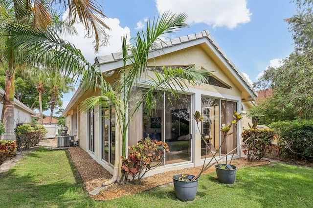 13853 Palm Grove Pl, West Palm Beach, FL 33418 - back of property with a lawn, central AC, and stucco siding