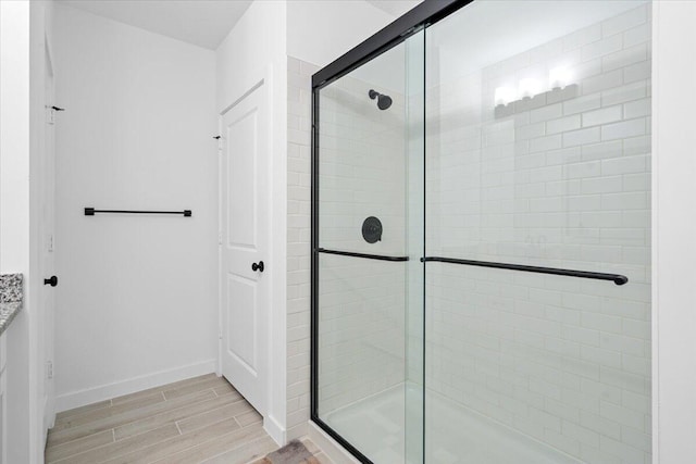 821 NE Trailside Run, Port Saint Lucie, FL 34983 - full bath featuring a shower stall, wood finished floors, and baseboards