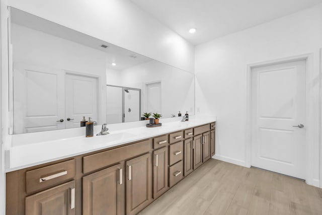 1246 Tangled Orchard Trce, Loxahatchee, FL 33470 - bathroom featuring a shower stall, double vanity, wood finished floors, baseboards, and recessed lighting
